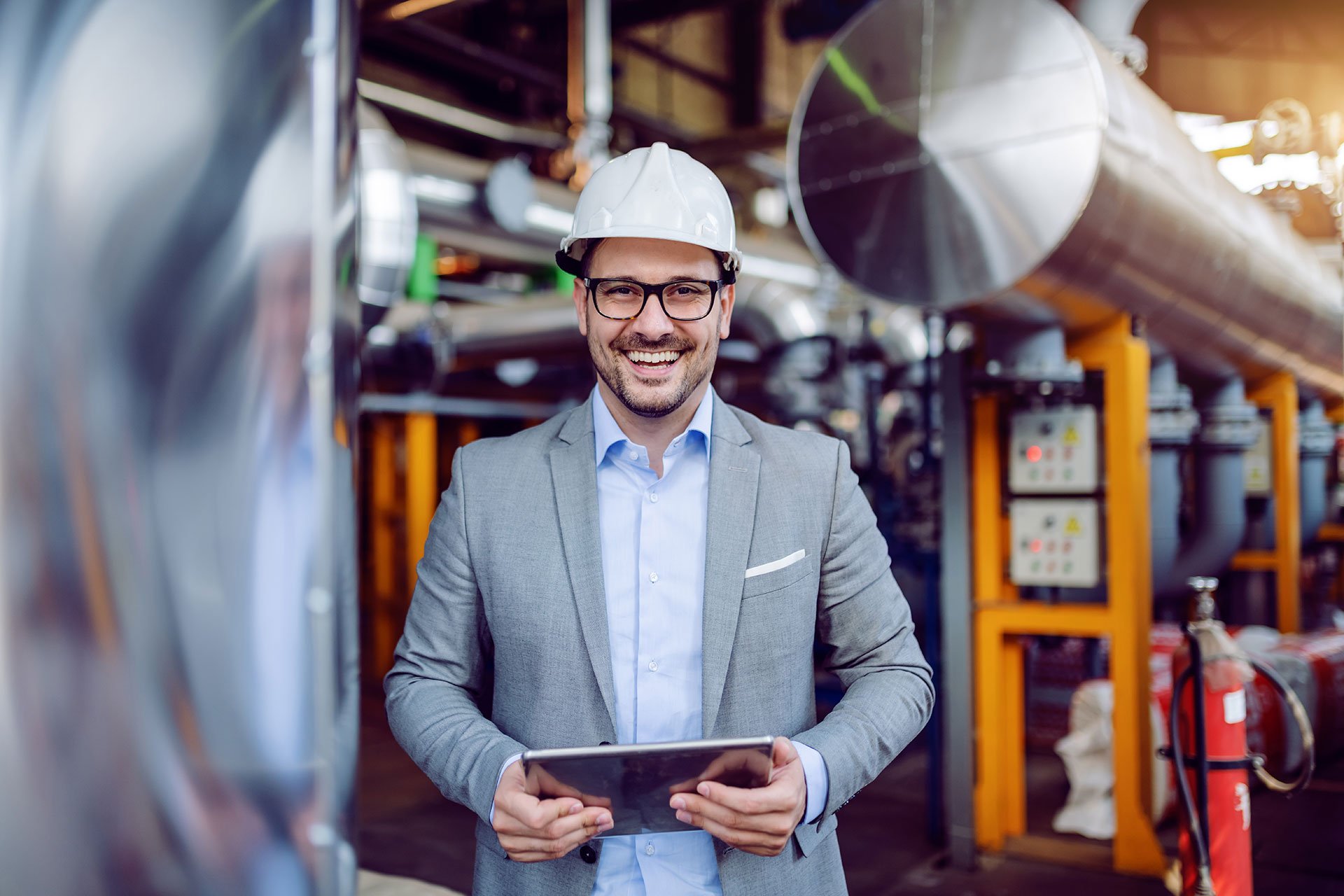 man with helmet and tablet in industrial environment